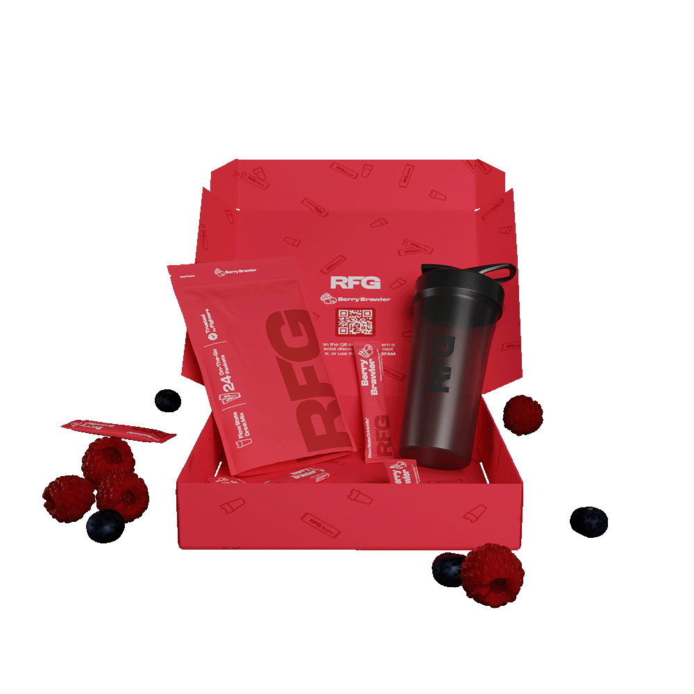 RFG pouch next to RFG shaker, next to RFG sticks all inside a red RFG box, on the sides there are strawberry, blueberry and raspberry fruits leaning on the box